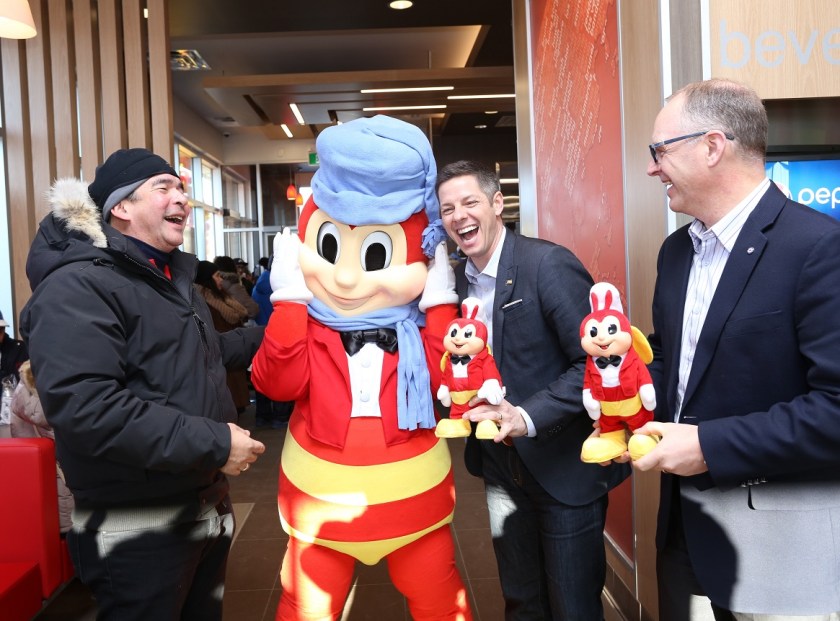 Winnipeg City Mayor Brian Bowman (middle), and City Councilor Scott Gillingham of St. James ward (right) share hearty laughter with Jose Miñana (left) and the Jollibee mascot as they receive exclusive Jollibee dolls to commemorate the occasion.